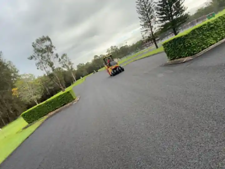 Newly laid asphalt car park being compacted with a roller